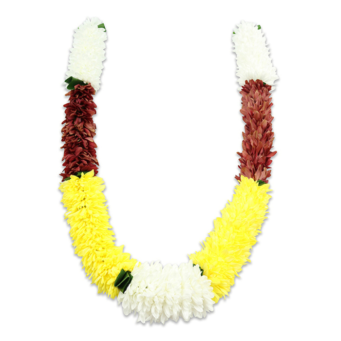 Presented flat against a pure white background, this handcrafted U-shaped garland reveals its craftsmanship in every visible petal and seam. The piece is made from artificial flowers chosen for longevity in ceremonial use: the top of each arm features a dense, cylindrical section of snowy white, chrysanthemum-like blooms whose soft, layered petals suggest quiet reverence; tiny, dark-green leaf accents sit at the tips to sharpen the contrast. Directly beneath the white caps a rich maroon band appears, its compact florets lending a grounded, almost earthen warmth before yielding to the broad, cheerful swathes of bright yellow that form the garland's sweeping lower curve. These yellow segments feel plush and abundant, reminiscent of marigold garlands used at weddings and temple rituals. At the centre bottom, where both yellow arms meet, a generous cluster of pure white flowers creates a focal point - wider and lusher than the top segments - balancing the composition and drawing the eye to the garland's heart. The studio lighting casts a soft shadow that articulates volume and the thousands of fabric petals that have been carefully stitched and layered. As a local florist working near Stanmore Broadway and Stanmore Country Park, Flowers Stanmore often prepares similar malas for pujas, temple offerings, wedding ceremonies and festivals; this style combines symbolic colours - white for purity, yellow for prosperity, maroon for devotion - with durability for repeated ceremonial display and local delivery across Stanmore and surrounding Harrow neighborhoods.