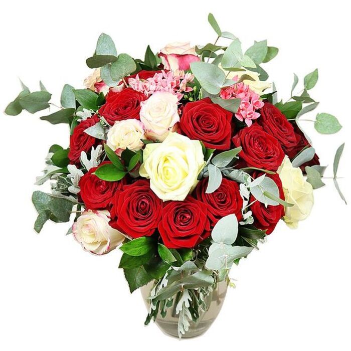 An opulent bouquet of roses is displayed in a clear glass vase, standing alone against a bright white background that throws every blossom and stem into sharp relief. The heart of the arrangement is a lush gathering of deep red and vivid scarlet roses, their velvety petals rich and saturated, some in tight, promising buds and others fully open in layered spirals that evoke passion and heartfelt emotion. Weaving in and out of these crimson blooms are creamy white and pale ivory roses, their softer tones bringing calm and contrast, like pockets of light within a sea of red. A number of these lighter roses are edged delicately with a hint of blush pink, adding a romantic nuance that gently links the white and red hues. Here and there, small bright pink filler flowers, possibly mini carnations or similar dainty blossoms, peek from between the larger petals, lending a fine, textured detail and a playful note to the composition. The bouquet is wrapped in a generous collar of rounded, blue-green eucalyptus leaves, their subtle silvery sheen offering a contemporary twist and suggesting a cool, refreshing scent that might drift through a Stanmore sitting room on a quiet afternoon. Beneath and between the blooms, deep green foliage and a touch of silvery-green leaves help to build volume, creating a full, rounded silhouette that looks expertly composed and abundantly generous. The glass vase tapers from a slightly bulbous base to a narrower neck, with the straight stems and clear water easily visible, reinforcing the sense of freshness and quality. It is a bouquet that feels perfect for a Stanmore anniversary dinner, a romantic surprise delivered near Stanmore Station, or a luxurious centrepiece for an intimate gathering at home.