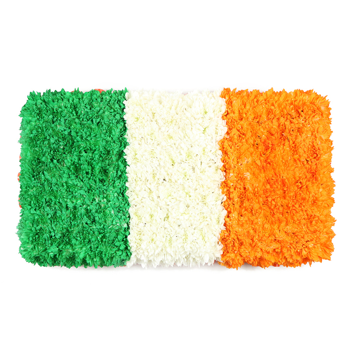 A striking rectangular tribute, this Irish tricolour is rendered in velvet-like petals that shade into texture and light. The left green band is a dense field of small green blossoms-likely chrysanthemums or carnations-creating a lush, tactile surface reminiscent of a leafy lawn in morning sun. The central white band is a tight cluster of white petals, resulting in a pure, luminous stripe that creates pause between the colours. The right orange band follows the same floral logic, its orange blooms giving a warm, radiant edge to the composition. The white backdrop emphasizes the trio of blocks, and the overall effect is both ceremonial and celebratory, a living flag rather than a flat print. Crafted with the care of a Stanmore florist, this piece speaks to heritage, unity, and shared celebration-perfect for Ireland-focused features, St Patrick's Day, or community acknowledgments. In Stanmore, Flowers Stanmore can arrange similar tributes with quick local delivery to Canons Park, Hale, and surrounding NW London neighborhoods, ensuring the symbol of peace and pride travels with freshness and grace.