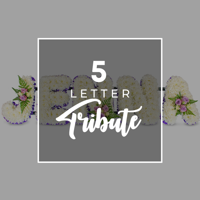 The photograph shows a custom five-letter floral tribute arranged horizontally against a cool, pale grey backdrop, reminiscent of the calm, uncluttered spaces often seen in Stanmore's local crematoria and chapels. Each of the five letters is generously proportioned and covered in a dense layer of white chrysanthemums, whose small, overlapping petals form a thick, padded texture that feels soft to the eye, inviting a sense of tenderness and care. Encircling every letter is a slim band of deep purple satin ribbon that traces each curve and corner, providing clear definition and a rich, sombre contrast that nonetheless remains graceful and understated. Interspersed throughout the white surface are tasteful accent clusters made up of pastel flowers and foliage: blush pink and lilac spray roses, petite mauve buds, and leafy fern fronds that arc lightly over the chrysanthemums, creating depth and subtle movement. The visible sequence of letters hints at a name - a distinct J, then O, with parts of H and N partially hidden behind a central overlay, and finally an A - suggesting how a full five-letter word or name could be tailored to honour an individual. In the middle of the tribute, set slightly above the flowers, lies a square overlay panel of deeper grey, framed with a crisp white border. On this panel, the wording 5 LETTER is rendered in white uppercase sans-serif type, with the word Tribute beneath in a more flowing, script style, clearly stating the style of arrangement without distracting from the blooms. The overall mood is one of composed, heartfelt remembrance, capturing the kind of personalised letter tributes often ordered from Flowers Stanmore for funerals and memorials across Stanmore, Belmont, and nearby Harrow Weald.