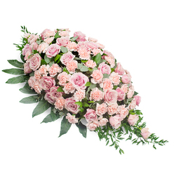 The image presents an elegant sympathy spray designed in a classic teardrop shape, ideal for a casket or memorial setting. At its broadest point, the spray is lavishly filled with soft pink roses, arranged so closely that their petals almost touch, forming a continuous wave of colour. The roses vary gently in tone from the palest blush to a warmer, peach-infused pink, and some appear fully open with layered, velvety petals, while others remain partially closed, adding texture and natural variation. Nestled between these roses are numerous light pink and peach-pink carnations, each with ruffled, fringed petals that give the arrangement a soft, plush feel. The carnations serve as a gentle filler, easing transitions between the larger blooms and ensuring there are no harsh gaps, only smooth, harmonious curves. Deep green foliage supports and frames the flowers. Broad, glossy leaves create a solid background along the length of the spray, while finer, more delicate stems and pointed leaves extend from the sides and from the tapered end, providing a graceful, flowing outline. Set against a pristine white backdrop, the pastel shades and the rich greens are clearly defined, emphasising the careful craftsmanship involved. The overall impression is one of calm dignity and tender affection, an arrangement that would feel at home at a Stanmore funeral service, perhaps in a local synagogue or church, or at a memorial gathering close to Bentley Priory. It speaks gently of shared memories and a loving farewell, much like a whispered goodbye in the quiet streets and green spaces around Stanmore.