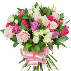 This densely packed, round bouquet reads as an affectionate embrace in pastel and jewel tones. At its centre, full-blown roses in blush pink and creamy ivory ripple outward, their soft, satiny petals layered like folded silk. Punctuating that gentle glow are vivid fuchsia roses and notes of pale lavender roses, which bring an energized, modern contrast while keeping the overall mood tender. Tiny spray roses - mainly creamy with a whisper of pale yellow - nestle close to the larger blooms, adding a textured intimacy and a sense of careful layering only achieved by hand-tying. Rich, dark green glossy leaves, likely ruscus or salal, peek and fan between blooms, offering a cool, clean visual pause and a natural frame for the rose colours. The stems are tightly gathered and finished with a wide, baby-pink satin ribbon, the bow's smooth sheen catching light and giving the arrangement a polished, feminine flourish. Imagine the soft scent of roses on a mild morning, the petals slightly velvety against fingertips; this is the quiet joy the bouquet evokes. Presented against a stark white backdrop that highlights every shadow and petal rim, the arrangement reads as refined and celebratory - ideal for sending affection on Valentine's Day, marking an anniversary, or surprising a mother on her special day. As a Stanmore florist I make bouquets like this to bring warmth and simple elegance to neighbours from Stanmore Hill to Marsh Lane.
