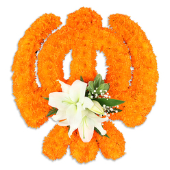 The heart of this composition is a luminous, tactile Khanda fashioned from densely clustered orange marigolds that read almost like a warm, woven cloth under soft light. Each marigold's plush texture is visible - tiny ruffled petals packed so closely they form a single, radiant surface that curves to describe the central chakkar, the two crossed kirpans and the downward-pointing dagger. At the intersection, a modest but striking cluster of pristine white lilies punctuates the orange: at least two fully open blooms with gently curling petals and pale green-yellow stamens, surrounded by a few smaller buds that promise further unfolding. Glossy green foliage and delicate sprays of gypsophila (baby's breath) are used sparingly to lift the composition, adding cool tone and airy contrast so the orange remains bold without overwhelming. A soft shadow beneath the piece confirms it is a crafted, freestanding display, intended as a respectful offering or ceremonial adornment. As a florist in Stanmore I imagine this displayed at community observances near Stanmore tube or brought to local gatherings in Canons Park; Flowers Stanmore prepares such tributes with an eye for balance, scent and solemnity. The arrangement balances warmth and quietness, a visual prayer in flowers that conveys devotion, unity and comfort - suitable for festival halls, memorial tables or a thoughtful presentation at a neighbourhood gurdwara - its fragrance and form inviting both sight and reflection.
