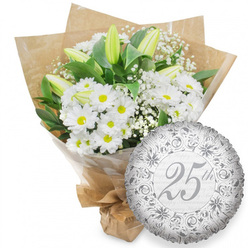 A quietly luxurious silver anniversary arrangement is shown here, composed as if by a careful local florist preparing a delivery for a home near Stanmore station. On the left, a substantial bouquet of fresh white flowers sits upright, its rounded shape filled almost entirely with open chrysanthemum daisies. Their bright, daisy-like faces feature rings of smooth white petals around cheerful yellow centres, bringing a soft, inviting warmth to the bouquet. Pushing gently through this sea of daisies are slender white lily buds, elongated and poised, their petals still held together with just a suggestion of green at the tips, promising elegant blooms that will open over time. Fine, branching stems of baby's breath are sprinkled throughout, each supporting clusters of miniature white blossoms that lend the arrangement a misty, romantic air. A layer of rich, dark green foliage frames the flowers, peeking through in measured bursts that give the design structure and a natural, garden-grown impression, akin to stepping into a leafy corner of Stanmore Country Park. The stems are secured first in a clear cellophane wrap that subtly reflects the surrounding light, then enveloped in brown kraft paper folded into wide, overlapping panels, creating a rustic yet stylish finish. The base is neatly tied, suggesting it is ready for collection or same-day delivery around Stanmore. To the lower right of the bouquet, a round silver foil balloon rests, its metallic surface gently dimpled where the light catches. At its centre, the number "25th" is written in an elegant script, framed by ornate scrolls and floral-inspired patterns in slightly darker silver. Behind this central motif, the phrase "Happy Anniversary" repeats faintly across the balloon, underscoring the silver jubilee theme. The image conveys an understated, deeply affectionate tribute to a 25-year marriage or partnership.
