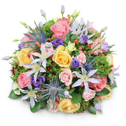 Captured against a crisp white background, this domed bouquet bursts outward in a carefully controlled wave of colour and texture, much like a showpiece created in a Stanmore flower boutique. At first glance, the eye is drawn to the abundance of garden roses in soft pink, creamy peach, and mellow yellow, their petals layered in gentle spirals that shift from tight, central curls to open, velvety edges. These classic blooms are interlaced with starry clematis blossoms in white and pale lavender, each one composed of slender, pointed petals arranged around a bright, golden centre, giving the bouquet a light, slightly whimsical feel. Piercing through the softness are distinctive blue eryngium thistles-sea holly with metallic blue-grey heads and spiky collars-adding an unexpected, contemporary note, like wild thistles seen on a walk through Stanmore Country Park. Deep purple lisianthus flowers and buds are scattered around the roses, some tightly wrapped, others just beginning to unfold, enriching the palette and lending a sense of gentle drama. Among these petals, clusters of bright red hypericum berries appear at intervals, their smooth, shiny spheres catching the light and providing cheerful pops of contrast. A foundation of layered greenery supports everything: broad, glossy leaves cup the base of the bouquet, while lighter, feathery foliage and a few strands of darker, wine-tinted leaves add depth and variation. The lighting is soft yet clear, with minimal shadow, allowing every texture-from the silkiness of the rose petals to the prickly eryngium-to be distinctly visible. The bouquet feels ideal for same-day delivery around Stanmore, whether you are marking an anniversary on The Broadway, welcoming a new baby near Canons Park, or sending a heartfelt gesture of appreciation to family nearby.