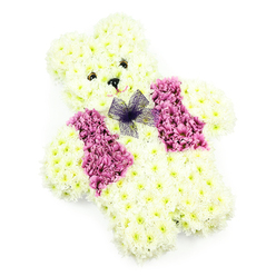 In this image, a teddy bear crafted entirely from fresh flowers sits serenely against a plain white background, an elegant and heartfelt funeral tribute. The bear's body is sculpted from masses of white chrysanthemums, with some petals carrying a creamy tint that adds warmth to the overall tone. These blooms are packed tightly together to shape the rounded head, soft belly, and sturdy paws, giving the impression of plush fur recreated in petals. The face is simple but expressive: two small, dark eyes, like tiny buttons, gaze forward softly, while a petite black nose and a subtle curve at the mouth create a calm, reassuring expression. Draped over the front of the bear is a floral waistcoat, crafted from blossoms in deeper shades of mauve and pink, reminiscent of hydrangea clusters or coloured chrysanthemums. These colourful blooms are arranged into two mirrored sections that sit neatly on the chest, forming the illusion of a tailored vest. At the top of this floral garment, just under the chin, a fine net bow in a gentle purple hue is tied delicately, its airy loops adding lightness and a hint of playfulness. The clear white background and even lighting allow each petal, curve, and detail to be seen distinctly. This style of floral teddy bear is frequently requested by families in Stanmore who are seeking a sensitive, childlike symbol for a funeral or memorial service, often chosen for ceremonies held near local churches or crematoria. Crafted with care by florists who understand the emotional weight of such occasions, it captures the feeling of a protective companion made entirely from flowers, offering comfort, remembrance, and quiet beauty.