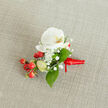 A close-up, top-down photograph of an elegant white orchid buttonhole resting on a softly textured, light beige woven fabric that looks like natural linen, the kind you might see on a table in a Stanmore High Street café. At the heart of the design sits a pristine Phalaenopsis orchid bloom, its broad white petals opening calmly, with a gentle wash of creamy yellow and soft orange tucked into the throat of the flower, adding warmth and depth. Around the orchid, tiny cloud-like clusters of white baby's breath float delicately, their many miniature florets creating a fine, airy halo that contrasts with the orchid's smooth, satiny surface. Tucked to one side is a glossy cluster of round red berries, rich and festive like holly, with a few paler green berry buds suggesting freshness and new life. These berries, likely hypericum, catch the light and add a joyful splash of colour beside the white blooms. Slender, vibrant green leaves of varying shapes weave in and out around the flowers and berries, bringing a lush, natural frame to the composition and echoing the greenery found in Stanmore's local parks. The stems at the base are neatly bound with a vivid red satin ribbon, wrapped with careful precision and tied into a small knot with short trailing ends, showing the steady hand of an experienced florist preparing a piece to be pinned to a suit lapel. The overall mood is refined yet welcoming, ideal for a winter wedding, Christmas celebration, or formal event in and around Stanmore, capturing both celebration and quiet sophistication in one small, beautifully crafted boutonniere.