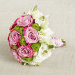 Resting on a softly lit, light beige linen, this bridal bouquet captures the gentle sophistication of a Stanmore wedding morning. The fabric beneath has a fine, woven texture, its neutrality allowing the flowers' colours to take centre stage. Dominating the left and centre of the arrangement are sumptuous pink roses, fully open and velvety. Their petals shift in tone from a tender, powder-pink at the inner whorls to an increasingly saturated fuchsia at the tips, creating a sense of depth and romance that feels both modern and classic. Between these roses, lime green button chrysanthemums sit like tiny spheres of spring, their tightly packed petals offering a structured, tactile contrast, almost like miniature topiary balls you might see in the manicured gardens around Stanmore Hill. On the right, a sweeping trail of white lisianthus softens the overall silhouette. The lisianthus blooms vary in openness, with some fully unfurled in silky layers of cream and white, and others still in graceful bud form, their pale surfaces promising more blossoms to come. The stems are bound together into a neat handle, cloaked in smooth blush pink satin that gives off a gentle sheen. Over this ribbon, slender strands of luminous white pearls have been wound with care, looping around in elegant spirals that hint at traditional bridal detailing. The overall impression is of a bouquet ready to be carried down the aisle at a ceremony near Stanmore Station or in a local synagogue or church: romantic yet poised, brimming with thoughtful craftsmanship and a sense of joy that feels intimately tied to a special day.
