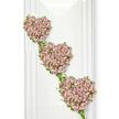 A graceful trio of floral hearts appears in a delicate vertical cascade against a flawless white background, forming a touching funeral tribute that feels both intimate and refined. Each heart is edged with strands of ivy and fresh greenery, the stems intertwining and looping to create a natural, slightly irregular frame that enhances the organic beauty of the design. Within the boundaries of each heart, countless miniature roses are gathered tightly together, their petals overlapping to form a plush, almost cushion-like surface. The roses are shaded in soft, romantic colours-dusty mauve, blush pink, and pale lavender-blending gently into one another like variations in a quiet sunset. The hearts are positioned so that the top sits a little left of centre, with the two below stepping gradually to the right, linked by slim trails of foliage that encourage the eye to follow the line of the arrangement. The stark white background, reminiscent of a calm, light-filled room at a Stanmore funeral venue or a peaceful corner near Stanmore's tree-lined streets, throws the delicate tones and textures into sharp relief while maintaining a sense of simplicity and calm. There are no distractions-no visible stands or ribbons-only the pure expression of love through flowers. Imagining the faint fragrance of fresh roses and greenery, this design feels like a quiet promise that the memory of the departed will remain alive in the hearts of those who loved them. It is a tribute well-suited to families in Stanmore seeking a symbol of enduring affection and dignity at a time of farewell.