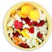 A circular, cream-yellow ceramic bowl fills the frame, seen from above so that its contents form a calm, colourful disc of petals, ready to be used in a farewell ritual or remembrance service in Stanmore. The bowl is heaped with freshly picked petals, mainly from roses, their shapes broad and gently cupped. Rich crimson reds, bright sunflower yellows, and subdued peach-apricot tones mingle together, creating a warm, sunset-like palette that feels both comforting and dignified. Threaded throughout this warmth is a generous scattering of small, ruffled white florets, similar to hydrangea petals, whose lighter tone and delicate texture lend a sense of purity and quiet reflection. The petals rest in an informal, organic arrangement, overlapping naturally rather than following a strict pattern, as though they have been lovingly poured in by hand. Soft, even light from above brings out the subtle sheen of the rose petals, while the white blooms appear almost translucent at the edges, giving the whole composition a gentle, airy quality. One can imagine the mild, sweet fragrance rising as the petals shift when someone reaches in to gather a handful. This bowl could sit beside a coffin, at a memorial table, or in a quiet corner of a reception room near Stanmore station, offering a simple, tactile way for family and friends to participate in saying goodbye. The combination of vivid colour and serene white makes the petals suitable for both traditional and contemporary funerals, expressing love, respect, and remembrance without overshadowing the moment's intimacy.