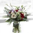 A bouquet that exudes gentle harmony, blending intense, velvety red roses with luminous white gerberas and pale lilac lisianthus, thoughtfully arranged by Stanmore florists with a nod to the area's garden heritage. Eucalyptus stems sweep outwards in silvery, cool arcs, creating a composition that feels both lush and untamed, capturing the spirit of Stanmore's open parks and leafy avenues. Pearly clusters of ivory filler flowers nestle into the arrangement, echoing the softness of early morning cloud cover over Stanmore. Glossy green leaves cradle the blooms at the base, bringing structure and a sense of abundance. The clear glass vase-and the crisp stems visible within-reinforce a feeling of purity and freshness. Designed to suit moments of gratitude, commemoration, or life's quiet celebrations, this locally inspired bouquet delivers both comforting warmth and crisp elegance, reflecting the tranquil charm and rich floral tradition of the Stanmore community.