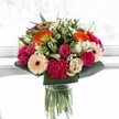 This sumptuous Stanmore bouquet gleams with vivacity-each bloom seeming to celebrate the moment in time. The energetic orange of gerberas suggests the warmth and bustle of local life along Marsh Lane, while blush pink roses and deep magenta carnations layer in romance and texture. Ivory roses and peach gerberas temper the arrangement, conveying understated elegance and a feeling of kindness. A halo of glossy greenery supports the structure, reminiscent of Stanmore's leafy avenues, and under the glow of bright, natural light, the bouquet's colours appear luminous, almost sparkling. Every petal's detail is unveiled, inviting the senses to experience both visual delight and emotional solace. Perfect for occasions both grand and intimate, this arrangement carries the hallmarks of expert local floristry-its beauty and harmony expressing the vibrant, heartfelt spirit of Stanmore and its welcoming community.