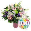 A vibrant 100th-celebration bouquet is captured in front of a pure white background, the kind of arrangement you might send to a cherished grandparent in Stanmore reaching their hundredth year. The flowers are gathered into a modern, ribbed vase finished in matte blush pink, which offers a gentle, contemporary base for the exuberant display above. Rising proudly from the centre, several light pink Oriental lilies stretch upwards, some fully open to reveal star-shaped petals and long stamens, others still in elegant bud form that promises future blossoms. Surrounding these lilies, an array of roses in soft blush and deeper mauve or dusty-rose tones create a lush, romantic heart to the bouquet, their velvety petals layered densely. Nestled among them are deep purple lisianthus, their ruffled blooms adding a hint of drama, while small lavender asters with golden-yellow centres pop through the design like miniature garden daisies. Bright lime green button chrysanthemums contribute a lively contrast, their rounded, textured heads giving the arrangement a modern edge. Airy sprigs of white baby's breath weave gently among the larger flowers, offering a light, cloud-like softness. The whole bouquet is framed by rich dark green foliage in mixed shapes, giving it volume and a natural, hand-crafted feel. To the lower right, a round foil balloon overlaps the composition, its glossy surface fully patterned with colourful confetti dots in bright red, orange, yellow, green, blue, and purple. Bold white numerals 100, rendered with a slight 3D effect, dominate the centre of the balloon, clearly signalling a centennial milestone. Together, the blooming arrangement and cheerful balloon convey a mood of joy, respect, and celebration for a life or love story spanning a full century in Stanmore.