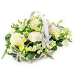 A softly coloured funeral flower basket is captured here against a plain white background, its gentle tones standing out with clarity and grace. The arrangement is cradled in a light wicker basket with a curved handle, its pale beige weave adding a touch of rustic simplicity. The flowers are arranged in a rounded, generous shape, giving the impression of an embrace. Large creamy white roses sit proudly at the centre, their petals fully unfurled in rich, velvety layers that speak of purity, love, and farewell. Around and between them, delicate clematis blossoms in pale lavender and soft periwinkle stretch their star-shaped petals, each bloom centred with a bright yellow-green eye that adds a soft spark of colour. Scattered throughout the arrangement are smaller, freesia-like flowers in white and pale lemon tones, some open in fragrant trumpets, others still neatly sealed in buds, suggesting both memory and new beginnings. The entire composition is wrapped in lush green foliage, from broad, glossy dark leaves to more slender, airy sprigs that curve and overlap, giving the basket depth and a naturally flowing outline. The colour scheme remains gentle and understated-ivory, cream, soft yellow, and lilac-creating a calm, reflective mood. It feels like an arrangement carefully crafted for a Stanmore family saying goodbye to a loved one, perhaps placed at a local chapel or delivered to a quiet home off Stanmore Hill. The careful balance of flowers and greenery reflects the work of an experienced florist in Stanmore, designing a tribute that brings solace, beauty, and a sense of dignified peace in a difficult moment.