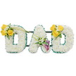 A tender, three-dimensional memorial arrangement spelling the word DAD in large capital letters, each letter formed from a dense, pillowy carpet of pristine white spray chrysanthemums that read as soft, cloud-like texture to the touch. The outer and inner edges of every letter are carefully finished with a ruffled, deep emerald-green satin ribbon that crisply frames the whiteness and gives each curve a defined silhouette against the plain white backdrop. Thin, dark green metal support bars run horizontally behind the letters and are faintly visible, revealing the thoughtful construction that keeps the trio standing as one cohesive tribute. The left 'D' is accented on its upper curve with a luminous cluster of three to four sunlit yellow roses, paired with delicate white freesias or gypsophila and fresh green foliage; two long, slender green stems arch diagonally across toward the centre, creating a gentle visual bridge. The centre 'A' carries a more contemplative grouping on its lower diagonal: two sculpted deep purple calla lilies-almost burgundy-nestled among small white filler blooms and glossy leaves, their trumpet forms giving a refined, reverent focal point. The right 'D' mirrors the left with a matching spray of yellow roses and white accents on its upper curve, balancing the composition. The overall scent is quietly clean-soft green leaves, faint citrus from the roses, and the cool, slightly powdery note of chrysanthemums-evoking early morning light over Stanmore Common. As a funeral or memorial piece, the arrangement reads as both dignified and personal, a crafted expression of love and remembrance designed to comfort mourners and honour a father's memory with calm elegance.