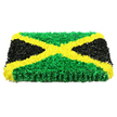 The image features a striking rectangular floral creation designed as a faithful, textural interpretation of the Jamaican flag, ideal as a funeral or memorial tribute. The base is completely hidden beneath a dense covering of fresh flowers, giving the piece a luxurious, padded look, as though it were a hand-stitched cushion made of petals. A bright golden yellow X dominates the arrangement, reaching cleanly from corner to corner. Each diagonal band is crafted from numerous small yellow blooms, their delicate, softly ruffled petals overlapping to form a rich, continuous swathe of colour. In the spaces between these arms of gold, the top and bottom triangles are filled with layered green flowers, their lively shade echoing the sense of calm greenery you might experience wandering through local Stanmore parks or gardens. The petals here are slightly tousled, adding a natural, organic feel to the structured design. On the left and right, deep black blossoms mass together into smooth triangles, their matte surfaces absorbing light and creating a powerful, contemplative contrast with the surrounding colours. The tribute is photographed against a clean white background, with bright, even lighting that reveals each ripple and fold of the petals without distracting shadows. The interplay of green, gold, and black feels both proud and tender, a floral representation of Jamaican identity that conveys warmth, history, and respect. It is easy to picture this arrangement being delivered to a Stanmore chapel or cemetery, offering a beautiful, symbolic farewell to someone whose life and roots are closely tied to Jamaica.