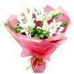 A sumptuous bouquet of white lilies and deep red roses is captured in front of a pristine white background, every detail of the flowers and wrapping carefully visible. The lilies rise proudly from the centre, their pure white petals forming wide, trumpet-shaped blooms that open away from a cluster of dark, cocoa-brown stamens. Some lilies are fully open, showing delicate speckles near the throat of the flower, while others remain in bud, sheathed in pale green that hints at blossoms yet to be revealed after the bouquet is delivered in Stanmore. Nestled between the lilies are deep red roses, their velvety petals tightly layered in compact buds or beginning to relax into gently opening cups, bringing a rich, romantic depth of colour. Surrounding the flowers, an abundance of dark green foliage provides structure and contrast: broad, shiny leaves create a solid, lush base, while fine, grass-like fronds thread upward through the arrangement, evoking a sense of natural movement like a breeze across Stanmore's open green spaces. The bouquet is wrapped in a collar of glossy, bright pink cellophane or tissue, slightly translucent and gathered in generous, ruffled folds that flare out around the blooms, giving a celebratory, gift-like feel. At the base, where the stems are cinched together, a narrow lime green ribbon is tied neatly, its satin texture catching small glints of light and accenting the fresh greens of the leaves. This carefully crafted bouquet feels perfect for marking anniversaries, birthdays, graduations, or heartfelt thank-you gestures within Stanmore, bringing both elegance and joyful colour into any room.