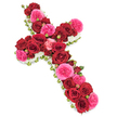 A graceful funeral cross made from an abundance of fresh roses is displayed against a bright, uncluttered white background, giving the arrangement a serene and reverent presence. The cross is entirely hidden beneath flowers, with deep red roses forming the main body of the design. These red blooms are fully open, their petals thick and velvety, layered in tight spirals that create a plush, almost cushion-like effect along both the vertical and horizontal arms. Threaded throughout this crimson base are clusters of vivid fuchsia and soft pink roses, some with the romantic fullness of garden varieties, their lightly ruffled petals softening the strong red tones and adding warmth. Here and there, smaller rosebuds and partially opened flowers peek through, lending extra dimension and the suggestion of memories unfolding gently over time. A slim but clearly defined border of tiny white blossoms, most likely spray chrysanthemums or petite carnations, runs around the very edge of the cross. This delicate fringe creates a bright, clean outline that enhances the cross shape and brings a sense of purity and peace to the overall composition. Subtle touches of green foliage and fine leaves appear just behind the blooms, providing enough contrast to make the colours sing while preserving the formal symmetry. Soft, even lighting allows every shade-from deep crimson and berry pink to pure white-to appear clear and balanced, reinforcing a calm, reflective mood. It is easy to imagine this floral cross resting by the altar of a Stanmore church or in a quiet chapel near Stanmore Country Park, offering a heartfelt, faith-filled farewell crafted with care by a local florist who understands the importance of a dignified final tribute.