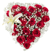 Set against a crisp white backdrop, this heart-shaped arrangement reads like a quiet, powerful declaration of love. Dozens of deep crimson roses-some held tight as velvet buds, others open into layered, velveteen cups-are clustered so densely that their rich petals form the very architecture of the heart. Soft clouds of tiny white baby's breath (Gypsophila) are woven through and around the roses, their star-like florets catching the light and lending an airy halo that softens the intense red. Nestled into the upper-left curve, an immaculate white lily unfurls its broad, sculptural petals; a faint wash of creamy yellow at its throat and slender yellow-orange stamens provide a luminous focal point that balances the composition. The bouquet's textures are tactile in description-the smooth, waxy lily, the plush rose petals, the feathered, almost powdery gypsophila-and a gentle, floral sweetness seems to rise from the cluster, as if the bouquet were breathing. The precise heart silhouette speaks to careful hand-crafting: each rose placed to maintain symmetry, each spray of baby's breath easing the transition from dense center to soft edge. In soft morning light the reds deepen into passionate garnets while the white elements glow with quiet purity. This design feels appropriate for an anniversary, a heartfelt Valentine's message, or a formal tribute; it carries romance without being brash and reverence without being austere. A Stanmore florist might imagine delivering this to a home near Canons Park or to a table on Stanmore High Street-an intimate, considered gift that communicates depth, tenderness, and expert floral care.