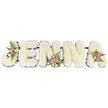 A tender and carefully crafted memorial spells the name JENNA in bold, three-dimensional block letters against a clean white backdrop. Each of the five letters is densely built from hundreds of small, creamy-white chrysanthemums - or flowers of similar delicate form - giving the letters a cloud-like, softly textured surface that reads as both serene and solemn. A slim band of deep purple trim lines the inner edges of every letter, like a gentle halo, defining the contours and lending cool contrast to the otherwise pure white composition. Three small, artful accent clusters punctuate the design: one nestles into the upper curve of the J, another settles along the lower centre of the second N, and a final spray crowns the upper right of the A. Those mini bouquets are composed of blush-pink and lavender spray roses, a few cream-to-pale-yellow roses for a warmer highlight, and feathery green fern fronds that add natural movement and depth. Thin, dark support bars discreetly join the letters, suggesting a sturdy framework that keeps the tribute unified without distracting from its floral surface. Soft, diffused light falls across the arrangement, bringing out the chrysanthemums' fine textures and the roses' gentle hues while emphasizing the peaceful mood appropriate for a funeral or memorial service. As a custom floral name tribute, this piece offers a personal, respectful way to honour a life - a quiet statement of love and remembrance that would be fitting for services held near Stanmore Broadway or in local church halls around Canons Park.
