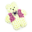 A tender teddy bear-shaped floral tribute is captured here, resting against a bright white background that highlights its soft colours and thoughtful construction. The entire bear-from rounded ears to chubby paws-is composed of small, tightly packed chrysanthemums in shades of white and pale cream, creating a thick, velvety surface that feels visually similar to plush fabric. The petals overlap neatly, defining the curves of the cheeks, the arc of the belly, and the comforting shape of the arms. The face is simply yet clearly detailed: two dark, button-like eyes offer a gentle, almost watchful expression, while a little black triangular nose and a subtle curved smile add personality and warmth. Over the front of the bear, a floral waistcoat provides a splash of colour, designed from clusters of blooms in rich pink, mauve, and soft magenta. These blossoms are grouped into two matching sections that sit on either side of the chest, like lapels, giving the impression that the bear is dressed for a special, meaningful occasion. At the top, just under the chin, a delicate bow made from fine purple netting is tied in graceful loops, lending a touch of elegance and playful charm. Soft, even lighting ensures that every petal and contour stands out without harsh shadows. This kind of floral teddy bear is often selected by families in Stanmore for children's funerals, memorials, or deeply personal tributes, offering a symbol of love, innocence, and enduring care. It feels like a floral companion, quietly present at services held near local churches and cemeteries, expressing emotions that can be difficult to put into words.